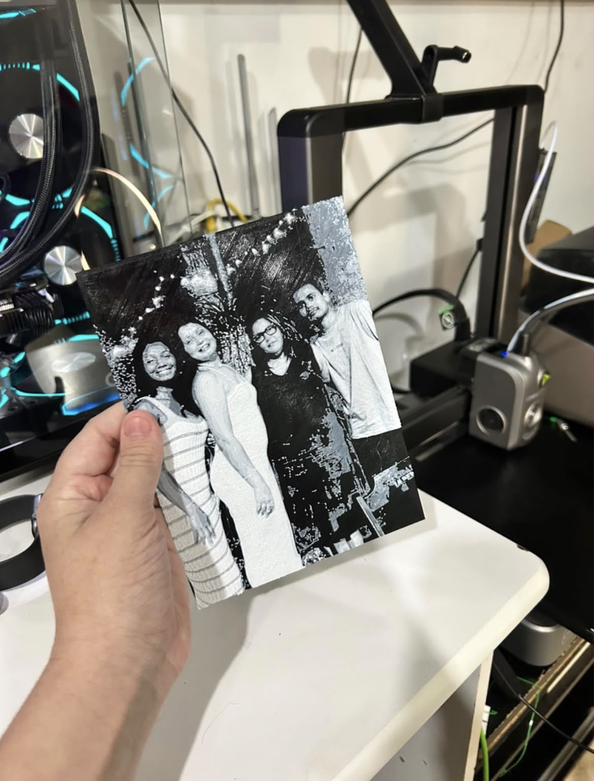 Quadro impresso com retrato em preto e branco de uma família, segurado diante da impressora